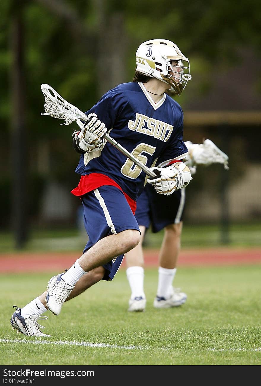 Man in Blue and White Jersey Playing Lacrosse