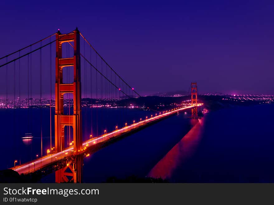 The Golden Gate Bridge by night and its reflection on the river surface.