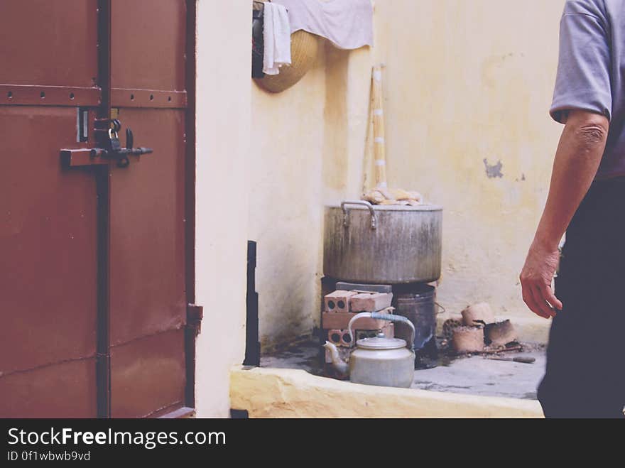 Old fashioned cooking equipment and a man standing next to it.