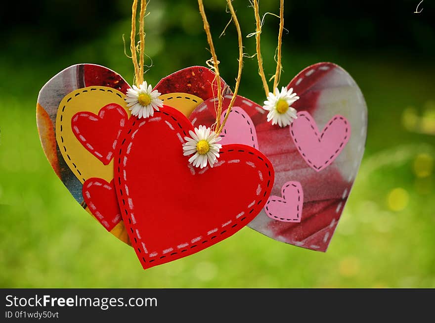 Three Red Hearts Hanging With White Flowers