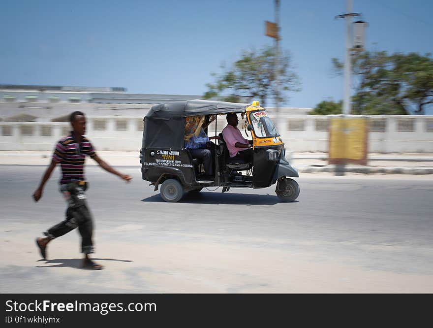 A 3-wheeled motorised taxi known as a &#x27;Tuk-Tuk&#x27; carries a passenger through thes treets of the Somali capital Mogadishu, 01 September 2013. Of one of many new modes of transport for people in Mogadishu, the Mogadishu Taxi Company has been operating since the end of May of this year in the city&#x27;s dusty and once again bustling streets and thoroughfares. The MTC&#x27;s distinctive yellow and purple cars offer customers taxi fares around Mogadishu at competitive rates and in the first 3 months of operations, the company has increased it&#x27;s fleet of vehicles from an initial 25 to over 100. The company, according to one of it&#x27;s drivers, also enables employment opportunities for Somalia&#x27;s youth following two decades of conflict in the Horn of Africa nation that shattered a generation. Now, thanks to the relative peace that has followed the departure of the Al-Qaeda-affiliated extremist group Al Shabaab from the city; an internationally recognised government for the first time in years and thousands of Diaspora Somalis returning home to invest in and rebuild their country, the MTC is one of many new companies establishing itself in the new Mogadishu and offering services that were hitherto impossible to provide. AU-UN IST PHOTO / STUART PRICE. A 3-wheeled motorised taxi known as a &#x27;Tuk-Tuk&#x27; carries a passenger through thes treets of the Somali capital Mogadishu, 01 September 2013. Of one of many new modes of transport for people in Mogadishu, the Mogadishu Taxi Company has been operating since the end of May of this year in the city&#x27;s dusty and once again bustling streets and thoroughfares. The MTC&#x27;s distinctive yellow and purple cars offer customers taxi fares around Mogadishu at competitive rates and in the first 3 months of operations, the company has increased it&#x27;s fleet of vehicles from an initial 25 to over 100. The company, according to one of it&#x27;s drivers, also enables employment opportunities for Somalia&#x27;s youth following two decades of conflict in the Horn of Africa nation that shattered a generation. Now, thanks to the relative peace that has followed the departure of the Al-Qaeda-affiliated extremist group Al Shabaab from the city; an internationally recognised government for the first time in years and thousands of Diaspora Somalis returning home to invest in and rebuild their country, the MTC is one of many new companies establishing itself in the new Mogadishu and offering services that were hitherto impossible to provide. AU-UN IST PHOTO / STUART PRICE.