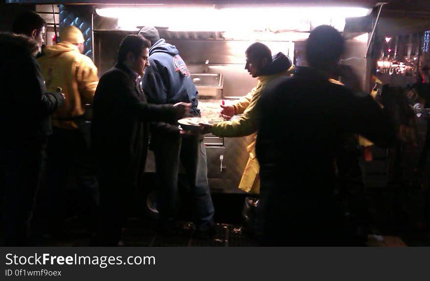 Diners at table outside food truck at night. Diners at table outside food truck at night.