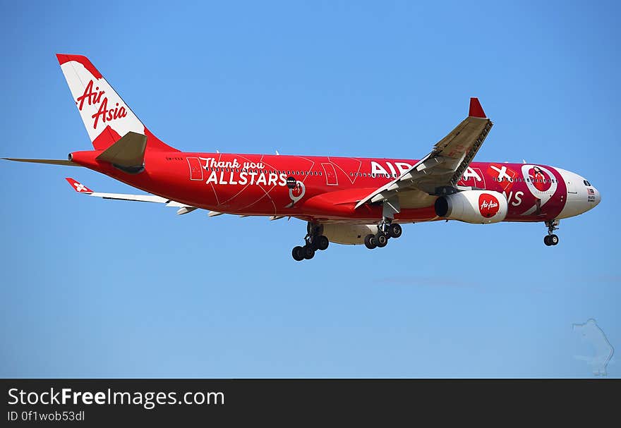 Air Asia airplane in flight against blue skies. Air Asia airplane in flight against blue skies.