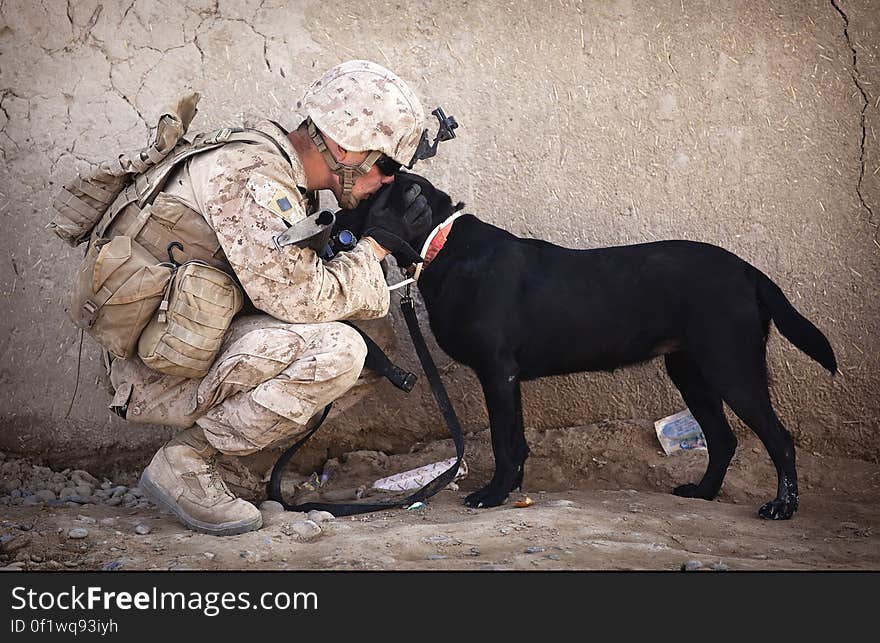 Soldier and Black Dog Cuddling