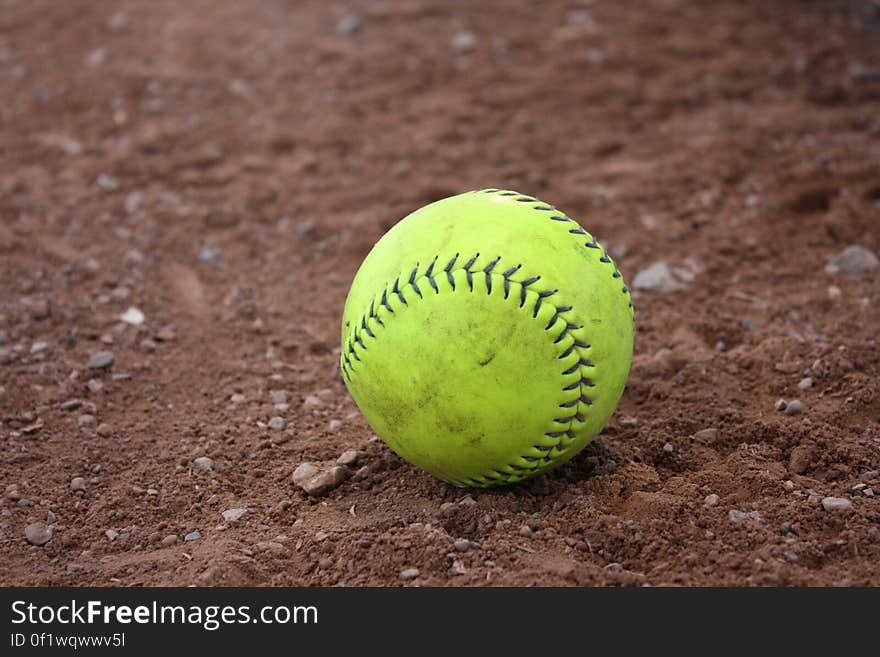 Yellow and Black Tennis Ball in Brown Soil