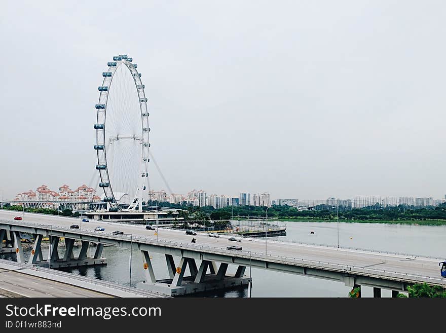 Scenic view of Singapore City Flyer and skyline with road bridge in foreground.