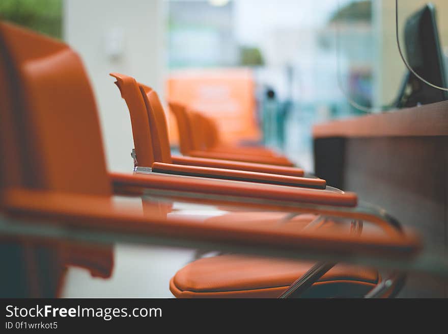 A close up of a row of orange armchairs. A close up of a row of orange armchairs.