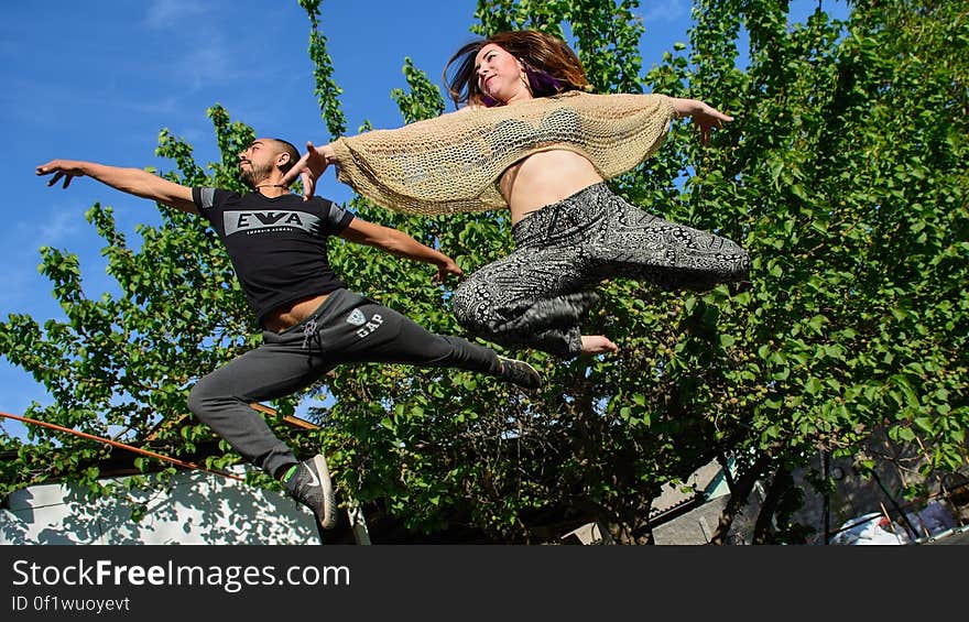 Woman in Black and Grey Pants Beside Man in Black Gap Pants Surrounded by Trees