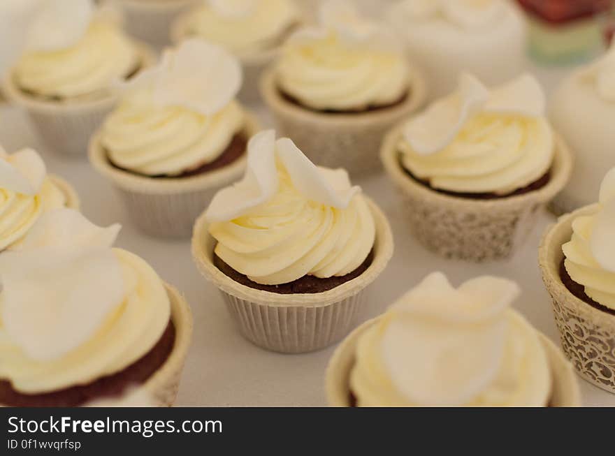 Vanilla swirl frosted cupcakes in decorative paper liners.