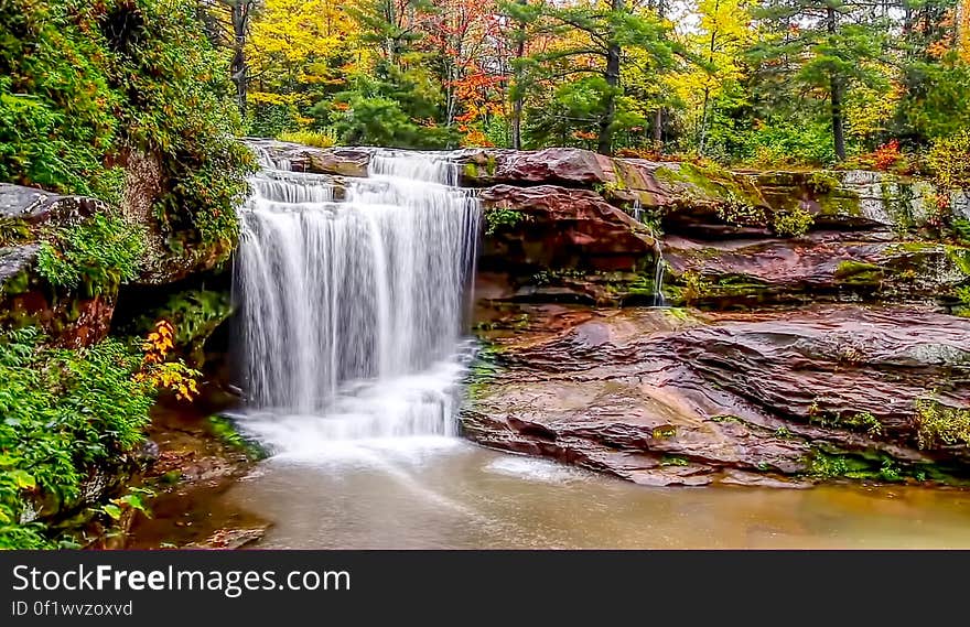 Waterfall over flat rocks in the autumn forest. Waterfall over flat rocks in the autumn forest.