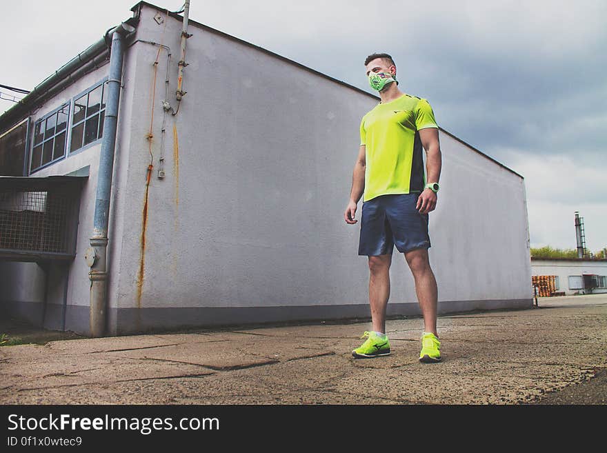 Man in Yellow T Shirt Standing Near the Wall