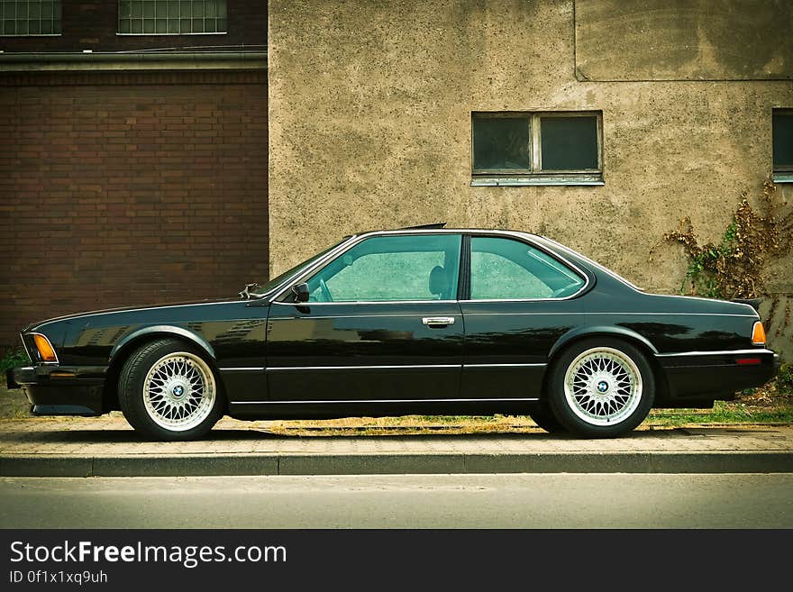 Black Sedan Parked Near Gray House