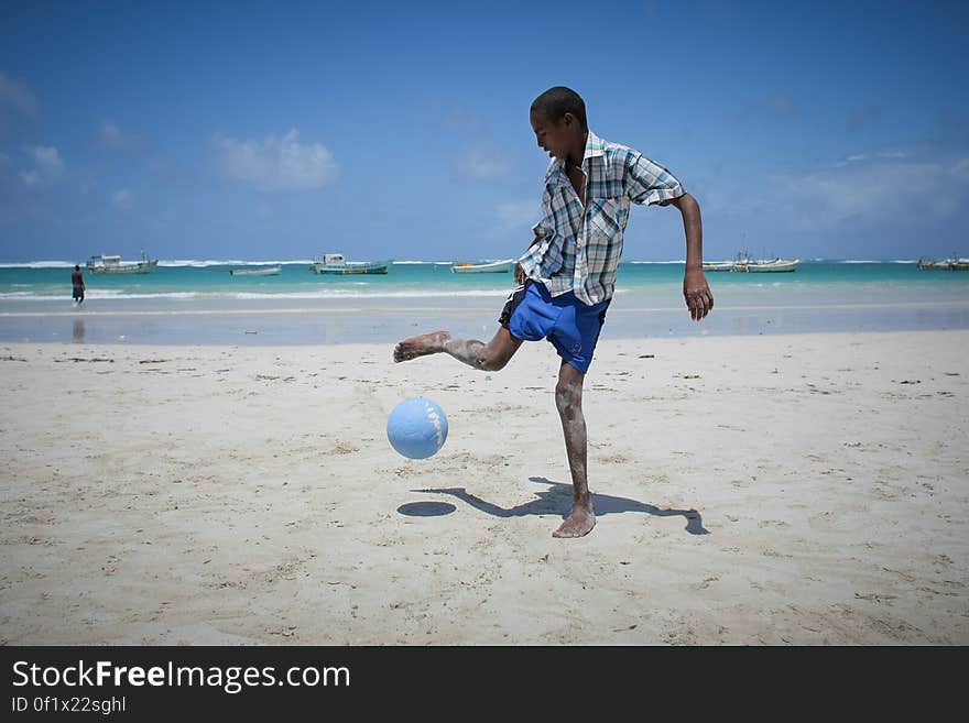 A Somali boy plays football on Lido Beach in the Kaaraan district of the Somali capital Mogadishu, 05 August, 2013. 06 August marks 2 years since the Al Qaeda-affiliated extremist group Al Shabaab withdrew from Mogadishu following sustained operations by forces of the Somali National Army &#x28;SNA&#x29; backed by troops of the African Union Mission in Somalia &#x28;AMISOM&#x29; to retake the city. Since the group&#x27;s departure the country&#x27;s captial has re-established itself and a sense of normality has returned. Buildings and infrastructure devastated and destroyed by two decades of conflict have been repaired; thousands of Diaspora Somalis have returned home to invest and help rebuild their nation; foreign embassies and diplomatic missions have reopened and for the first time in many years, Somalia has an internationally recognised government.. AU-UN IST PHOTO / STUART PRICE. A Somali boy plays football on Lido Beach in the Kaaraan district of the Somali capital Mogadishu, 05 August, 2013. 06 August marks 2 years since the Al Qaeda-affiliated extremist group Al Shabaab withdrew from Mogadishu following sustained operations by forces of the Somali National Army &#x28;SNA&#x29; backed by troops of the African Union Mission in Somalia &#x28;AMISOM&#x29; to retake the city. Since the group&#x27;s departure the country&#x27;s captial has re-established itself and a sense of normality has returned. Buildings and infrastructure devastated and destroyed by two decades of conflict have been repaired; thousands of Diaspora Somalis have returned home to invest and help rebuild their nation; foreign embassies and diplomatic missions have reopened and for the first time in many years, Somalia has an internationally recognised government.. AU-UN IST PHOTO / STUART PRICE.