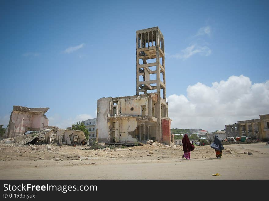 Two women walk past bombed-out and destroyed buildings in the Boondheere district of the Somali capital Mogadishu, 05 August, 2013. 06 August marks 2 years since the Al Qaeda-affiliated extremist group Al Shabaab withdrew from Mogadishu following sustained operations by forces of the Somali National Army &#x28;SNA&#x29; backed by troops of the African Union Mission in Somalia &#x28;AMISOM&#x29; to retake the city. Since the group&#x27;s departure the country&#x27;s captial has re-established itself and a sense of normality has returned. Buildings and infrastructure devastated and destroyed by two decades of conflict have been repaired; thousands of Diaspora Somalis have returned home to invest and help rebuild their nation; foreign embassies and diplomatic missions have reopened and for the first time in many years, Somalia has an internationally recognised government.. AU-UN IST PHOTO / STUART PRICE. Two women walk past bombed-out and destroyed buildings in the Boondheere district of the Somali capital Mogadishu, 05 August, 2013. 06 August marks 2 years since the Al Qaeda-affiliated extremist group Al Shabaab withdrew from Mogadishu following sustained operations by forces of the Somali National Army &#x28;SNA&#x29; backed by troops of the African Union Mission in Somalia &#x28;AMISOM&#x29; to retake the city. Since the group&#x27;s departure the country&#x27;s captial has re-established itself and a sense of normality has returned. Buildings and infrastructure devastated and destroyed by two decades of conflict have been repaired; thousands of Diaspora Somalis have returned home to invest and help rebuild their nation; foreign embassies and diplomatic missions have reopened and for the first time in many years, Somalia has an internationally recognised government.. AU-UN IST PHOTO / STUART PRICE.