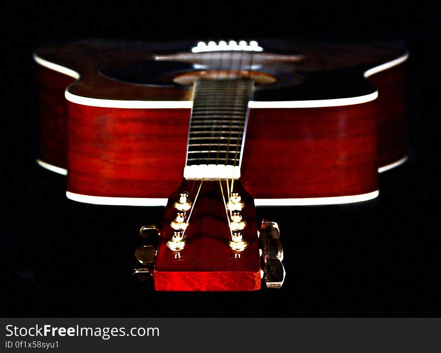 Close Up Photography of Red Wooden Guitar Head Stock