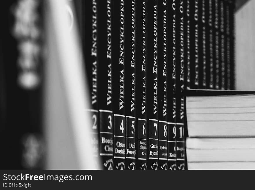 Set of encyclopedias on a shelf in black and white.