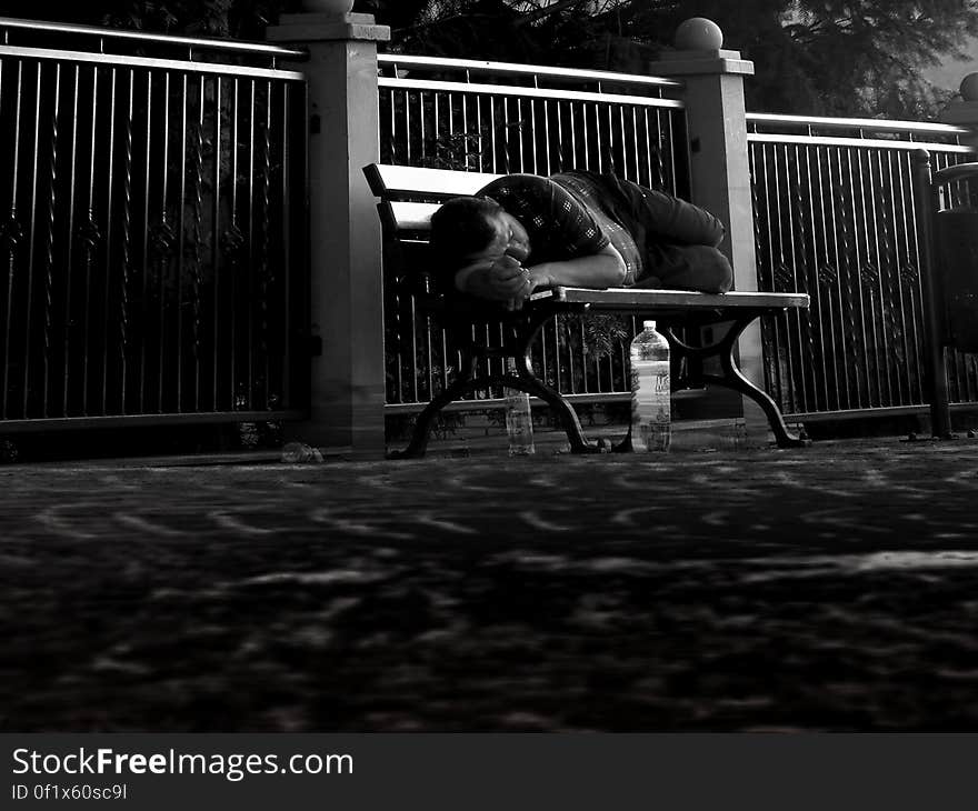 A man sleeping on a park bench. A man sleeping on a park bench.