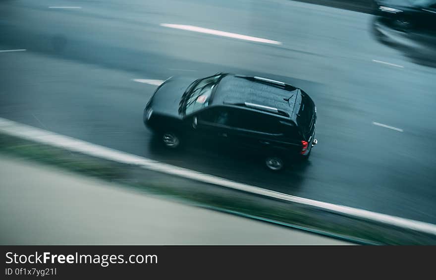 Aerial view of car driving on road with motion blur.