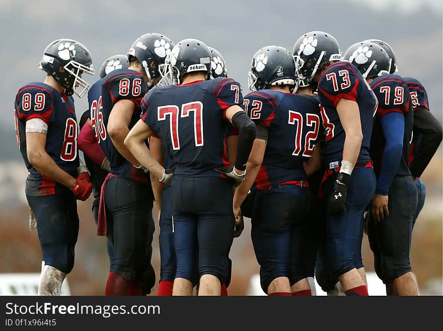 Huddle of American football players on a pitch.