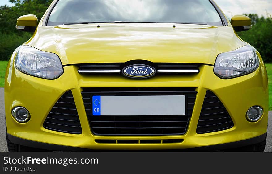 Front view of a yellow Ford motor car.