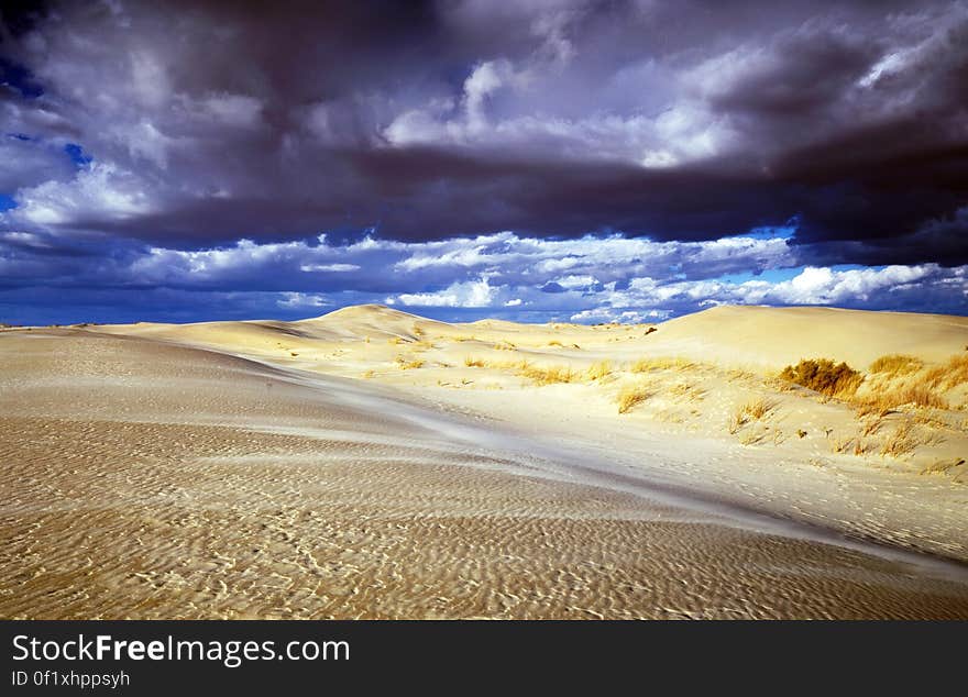 Dark storm clouds over sand dunes in desert landscape. Dark storm clouds over sand dunes in desert landscape.