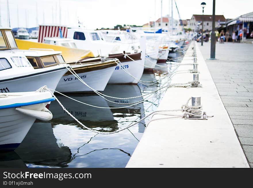 A row of anchored boats in a harbor. A row of anchored boats in a harbor.