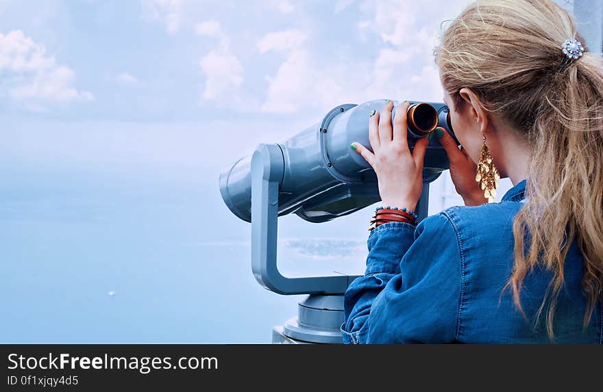 Woman in Blue Denim Jacket Holding a Gray Steel Tower Viewer