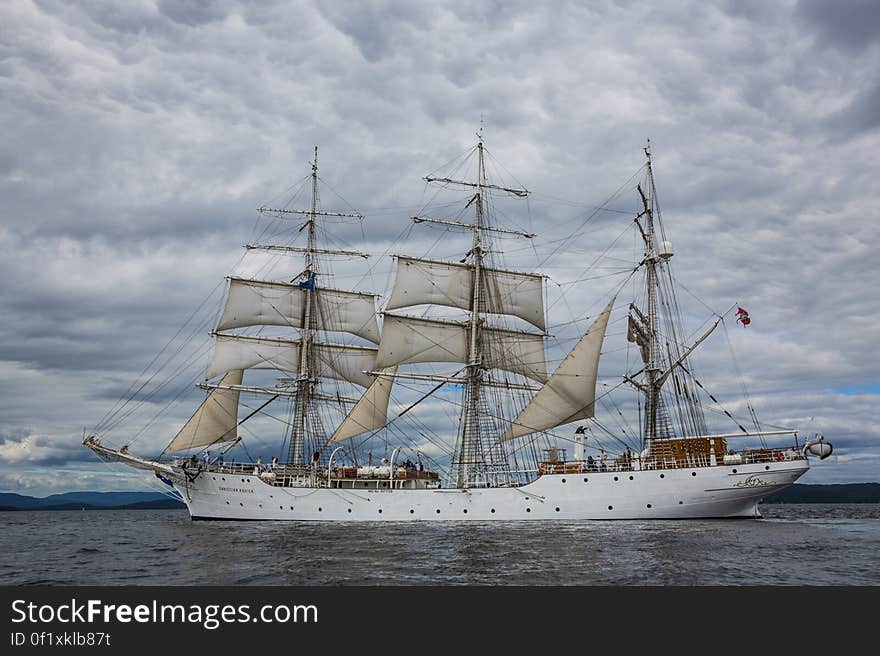 A floating sailboat in cloudy weather.