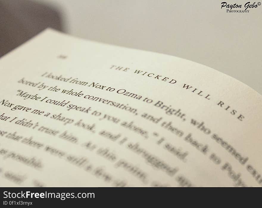 Closeup of a page from a best selling book entitled, "The wicked will rise" using selective focus on the title, cream background.