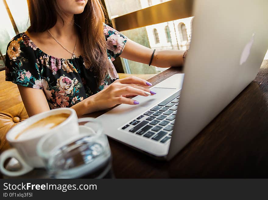 Woman Wearings Coop Neck Floral Top Using Her Apple Brand Macbook