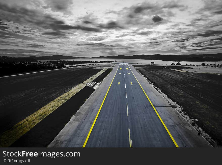 An aerial view of an empty runway near a coast. An aerial view of an empty runway near a coast.