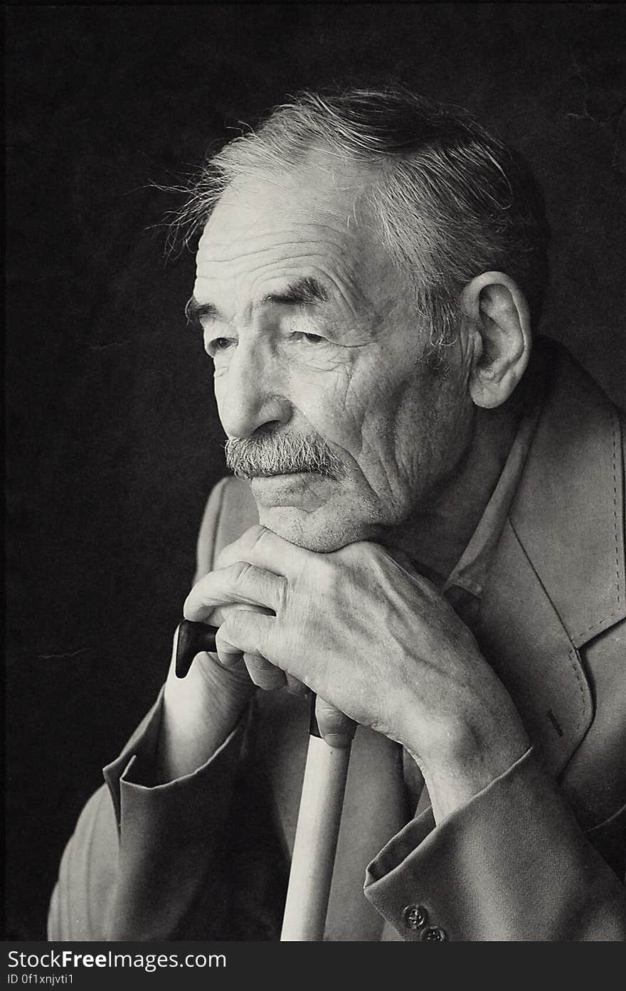 A black and white portrait of an elderly man with a cane. A black and white portrait of an elderly man with a cane.