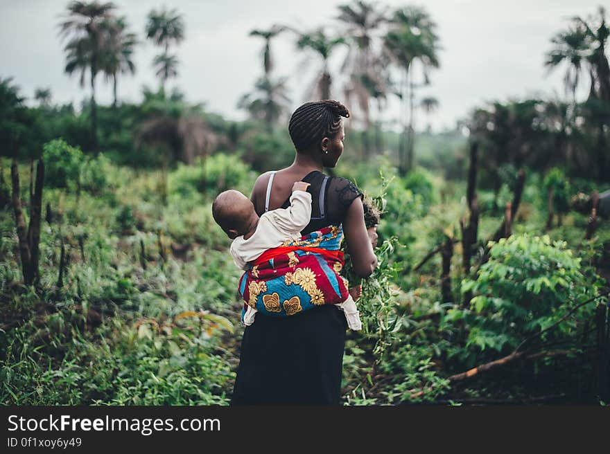 A woman with a baby carrier on his back. A woman with a baby carrier on his back.