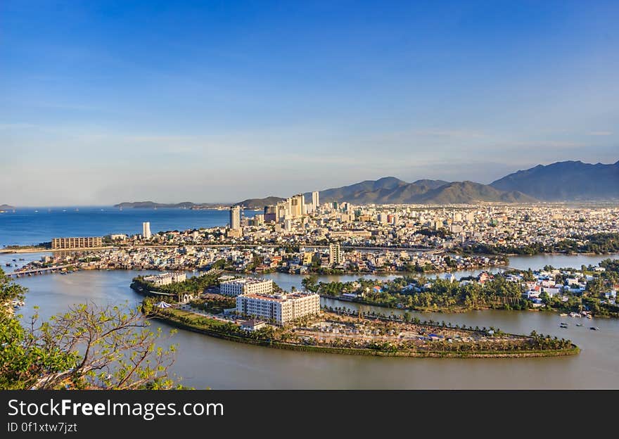 A panoramic view of a city on a seacoast and hillside in the background. A panoramic view of a city on a seacoast and hillside in the background.