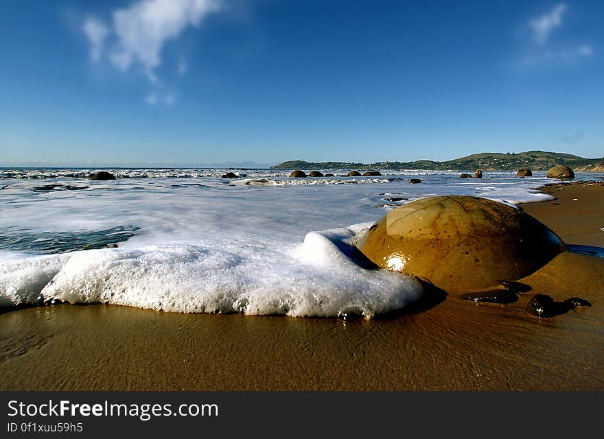 The Moeraki Boulders are geological marvels, exposed by erosion of sedimentary rocks laid down from 65 to 13 million years ago. They are formed by the gradual precipitation of calcite in mudstone over 4 million years. These spherical concretions are internationally significant for their scientific value and are a popular tourist attraction.