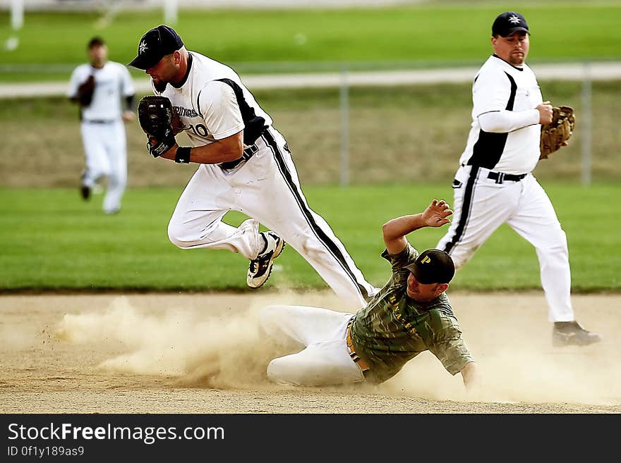 A baseball player running and sliding to base.