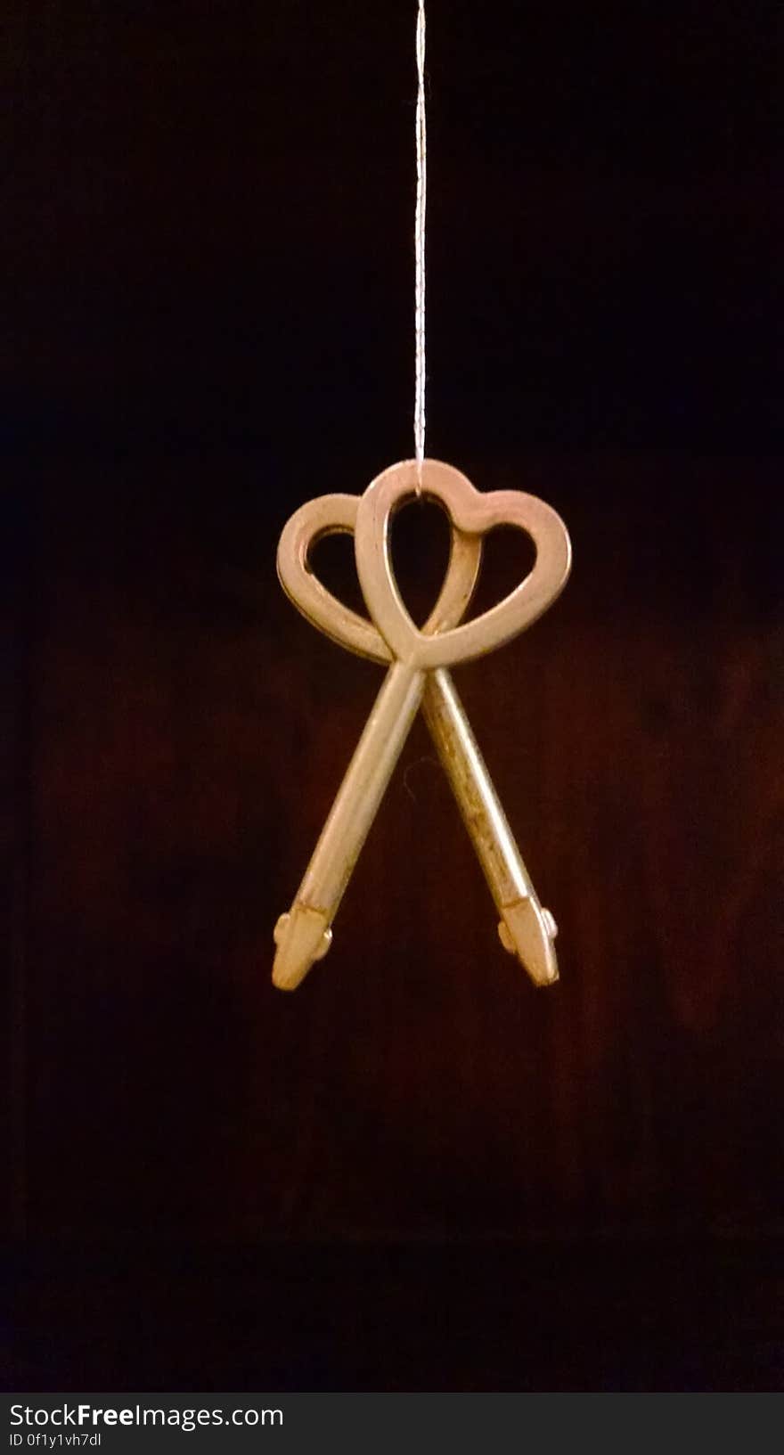 A close up of a hanging pair of heart shaped keys. A close up of a hanging pair of heart shaped keys.