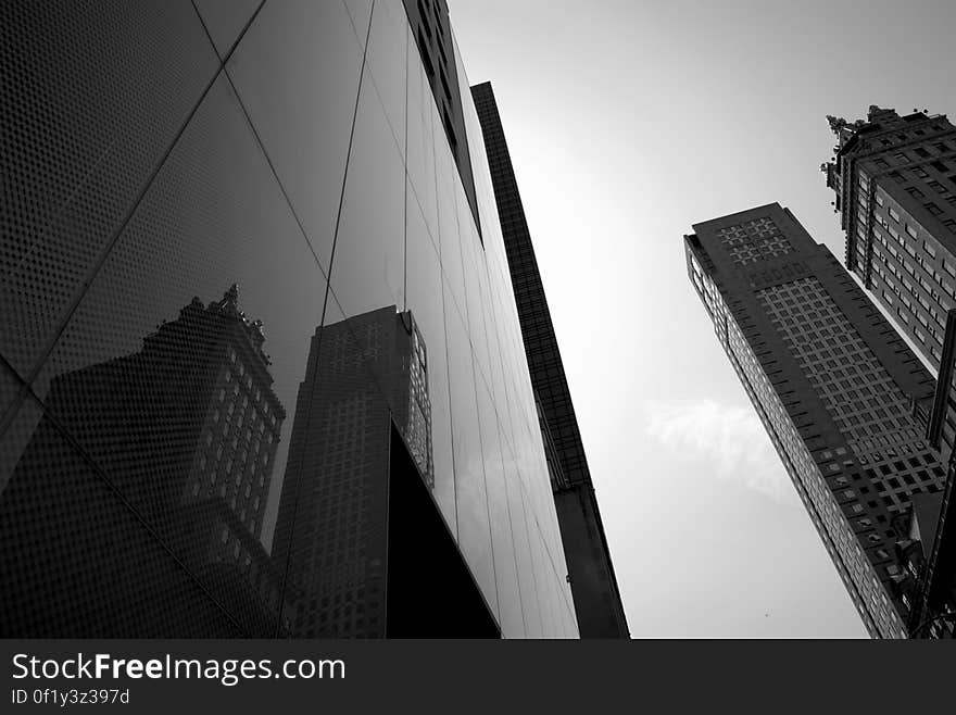 A view in a city with the facade of a glass skyscraper reflecting other buildings. A view in a city with the facade of a glass skyscraper reflecting other buildings.