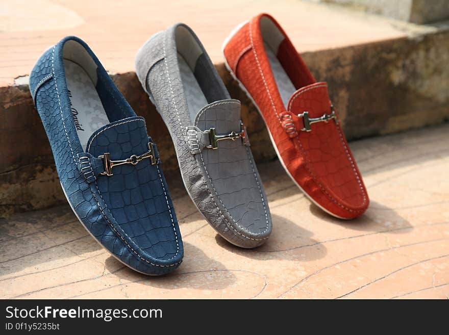 Three different colored fashionable men's leather shoes on wooden floor. Three different colored fashionable men's leather shoes on wooden floor.