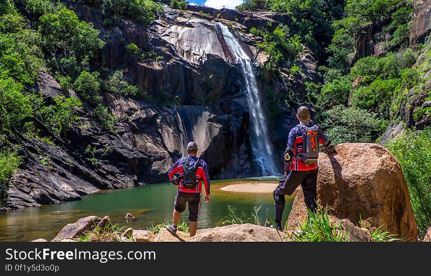 Rear view of two hikers stood at foot of tall countryside in countryside. Rear view of two hikers stood at foot of tall countryside in countryside.