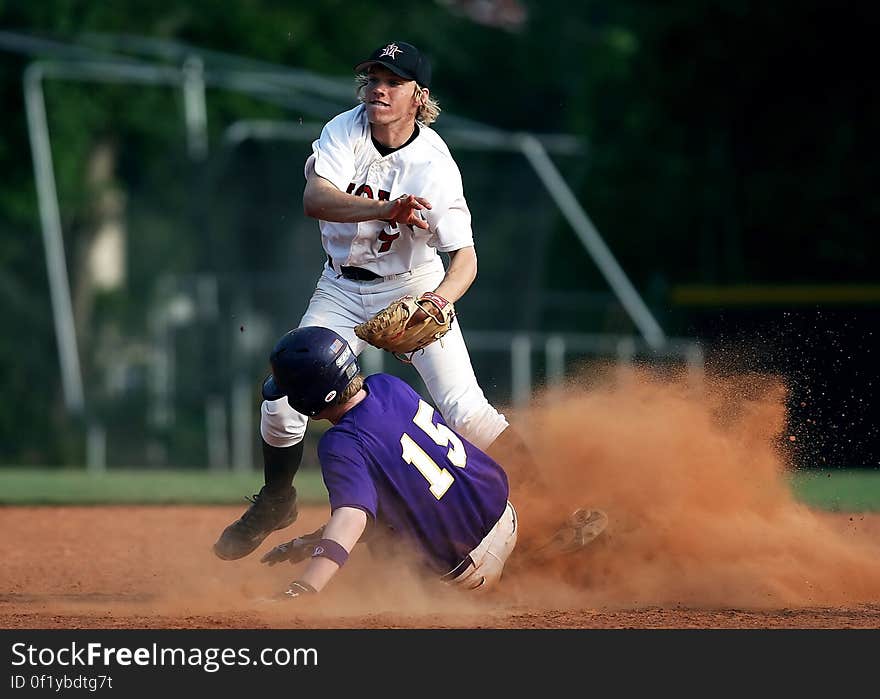 2 Man Playing Baseball on Brown Field