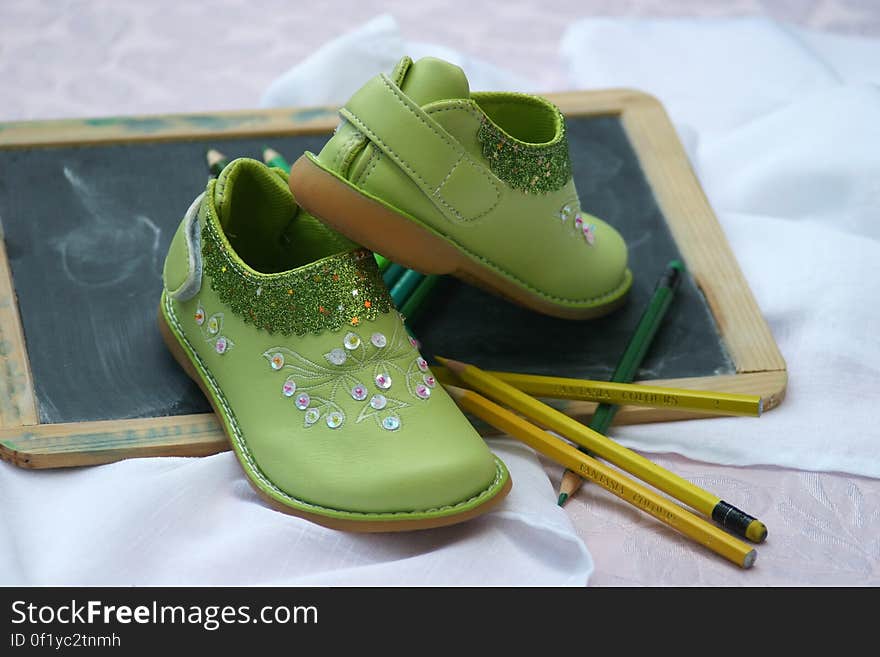 Green Slip on Shoes Near Yellow and Green Pencil