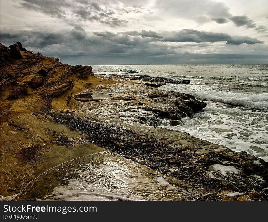 A view across a rocky coast with cloudy skies.