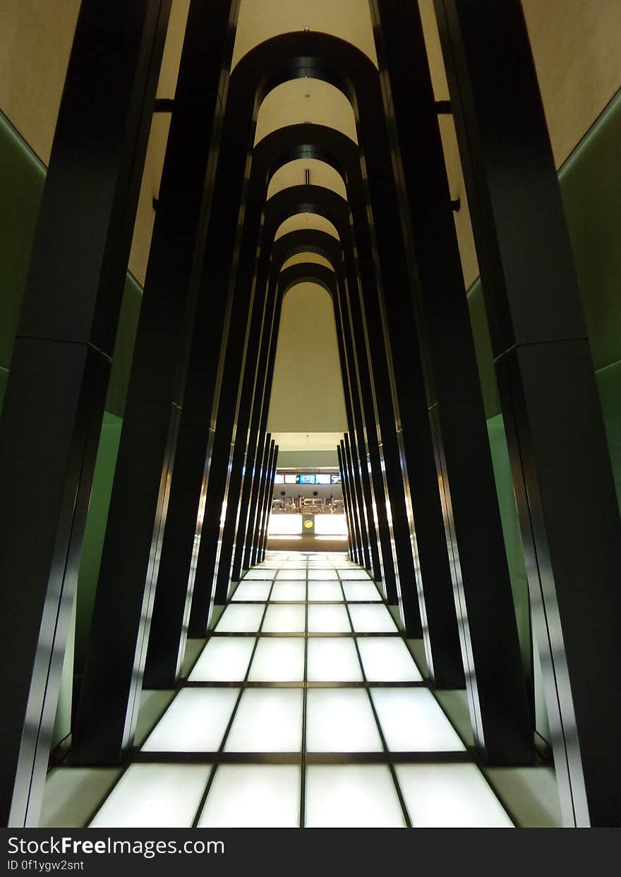 A passageway in an airport leading to the check-in desks. A passageway in an airport leading to the check-in desks.