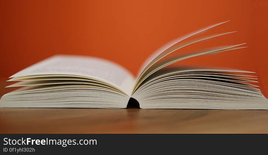 An opened book on a table with. An opened book on a table with