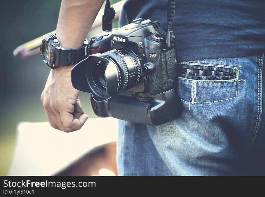 A man with a professional camera hanging at his hips. A man with a professional camera hanging at his hips.