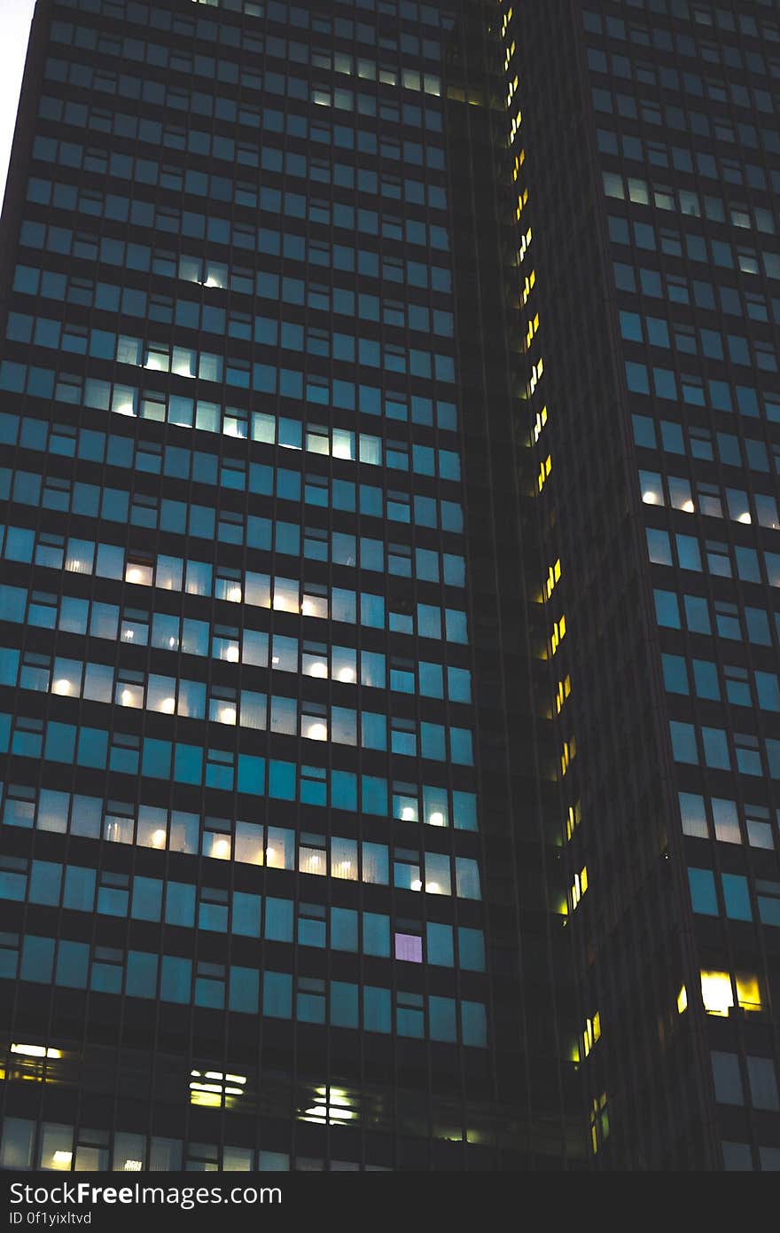 A view of a skyscraper with glass facade at night. A view of a skyscraper with glass facade at night.