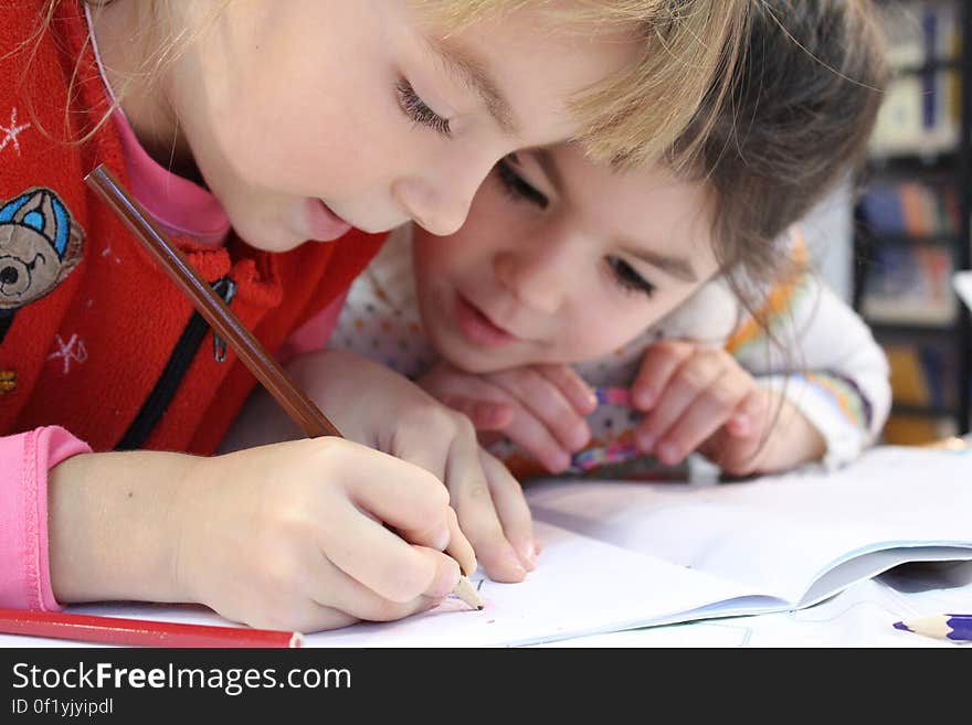 Girls on Desk Looking at Notebook