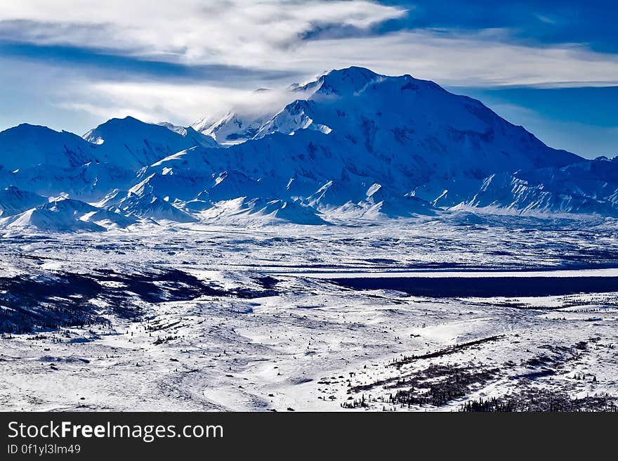 A mountain range and a valley below covered in snow. A mountain range and a valley below covered in snow.