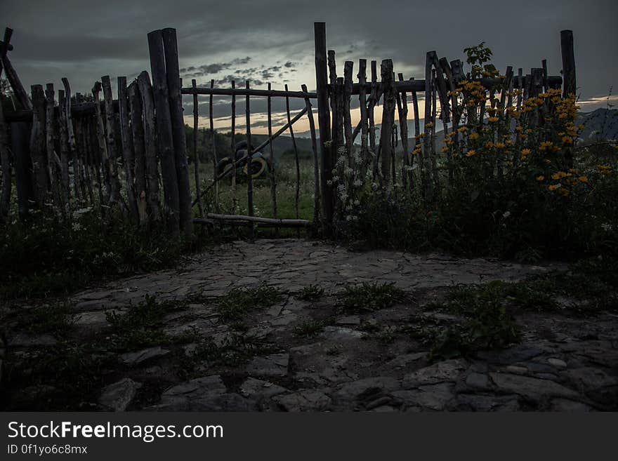 A countryside fence with flowers and rustic gate. A countryside fence with flowers and rustic gate.